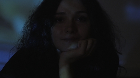 Portrait of a Young Woman Watching a Video or Film on TV or a Computer Monitor alt