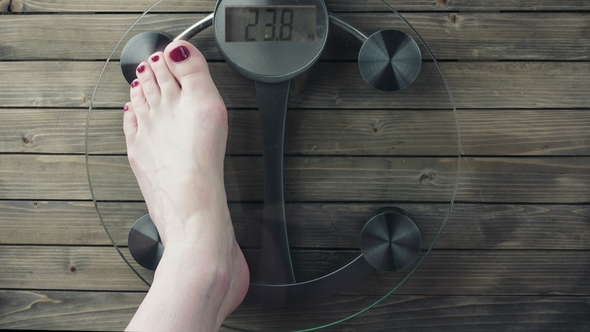 Female Measuring Weight on Health Scale