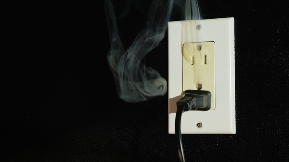 The Beginning of the Fire in an American Type Socket. Smoke Streams Come From a Double Home Outlet - alt