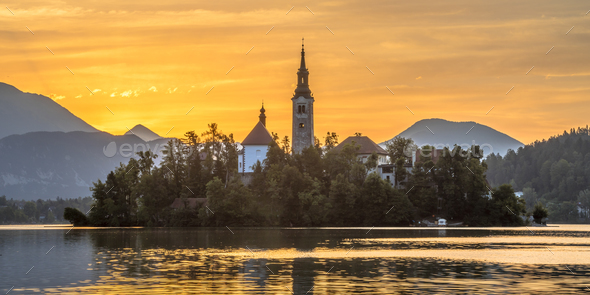 Famous landmark Island in Lake bled with church under orange mor - Stock Photo - Images