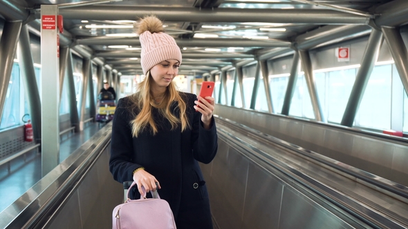 Young Woman Using Smartphone in Airport alt