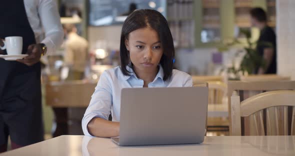 Waiter in Apron Serve Coffee to Businesswoman in Cafe alt