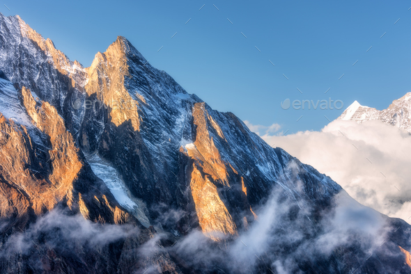 Mountains with sunlit peaks in clouds in Nepal - Stock Photo - Images
