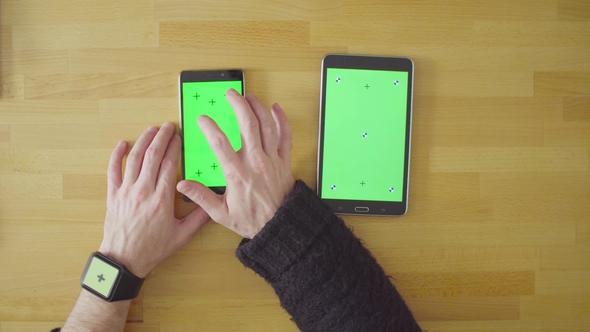 Three Devices with Green Screens on the Table