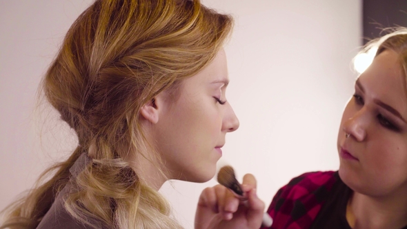 The Makeup Artist Applying Powder on the Face