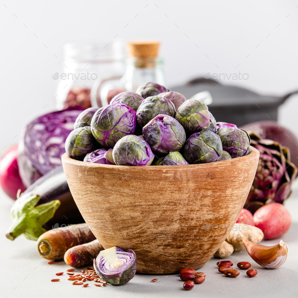 Purple Brussels sprouts in a wooden bowl - Stock Photo - Images