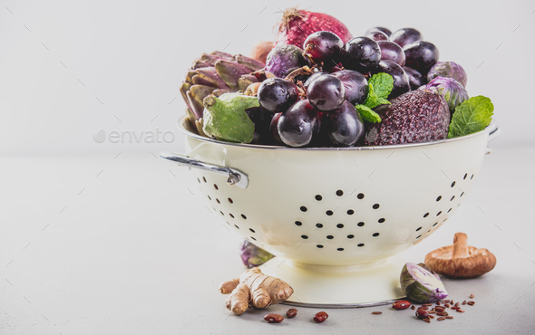 Purple fruits and vegetables in colander - Stock Photo - Images