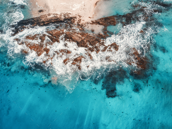 Aerial view of waves, rocks and transparent sea - Stock Photo - Images