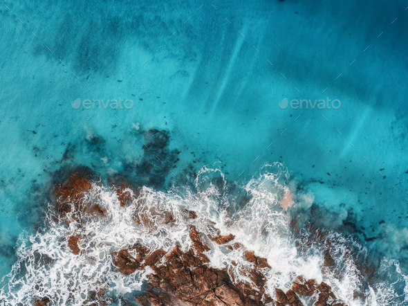 Aerial view of waves, rocks and transparent sea - Stock Photo - Images