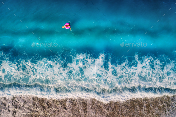 Aerial view of young woman swimming on the pink swim ring in the - Stock Photo - Images