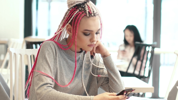 Portrait of a Girl with Dreadlocks in a Cafe. a Teenager with an Unusual Appearance. Subculture of alt