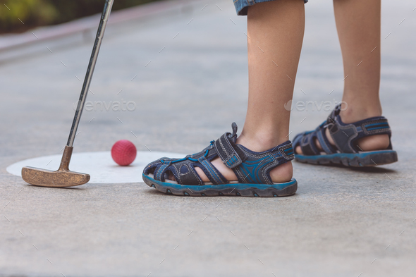 Happy little boy playing mini golf. - Stock Photo - Images
