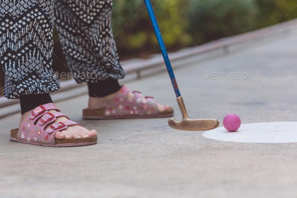 Happy little girl playing mini golf. - Stock Photo - Images