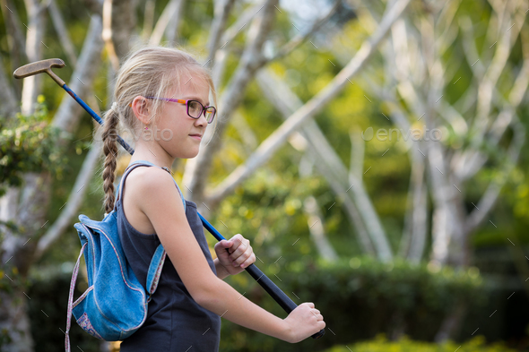 Happy little girl playing mini golf. - Stock Photo - Images