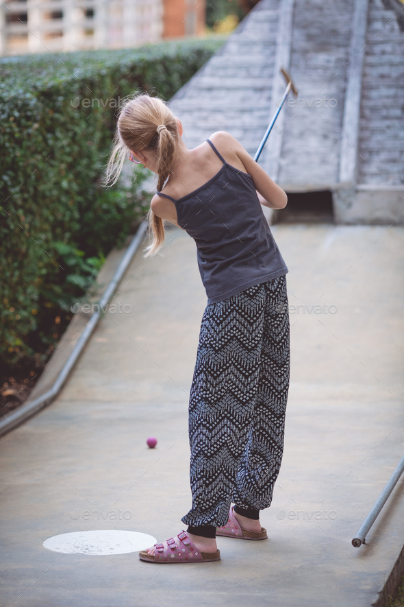 Happy little girl playing mini golf. - Stock Photo - Images