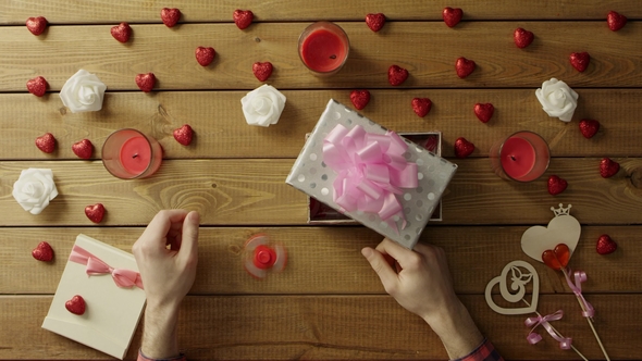 Young Man Puts Fidget Spinner Into the Gift Box As Holiday Present, Top View alt