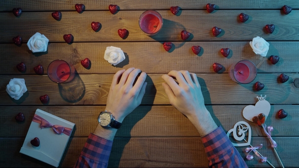 Male Sits By Table with Luxury Watch on His Hand and Waits, Top View
