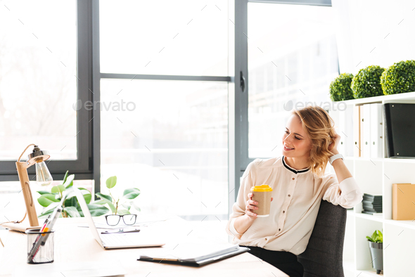 Portrait of a happy young businesswoman working - Stock Photo - Images