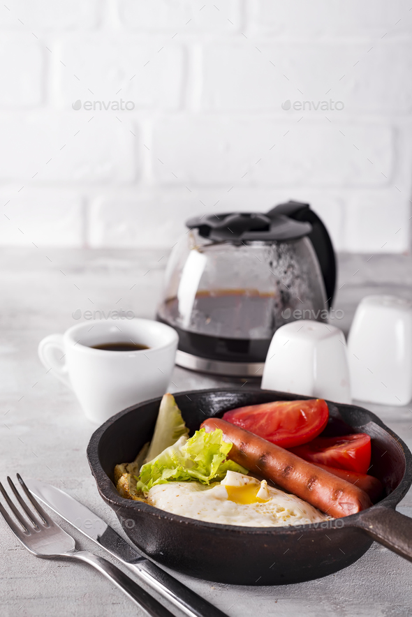 Homemade delicious american breakfast with fried egg, toast, sausage, vegetable, black coffee - Stock Photo - Images