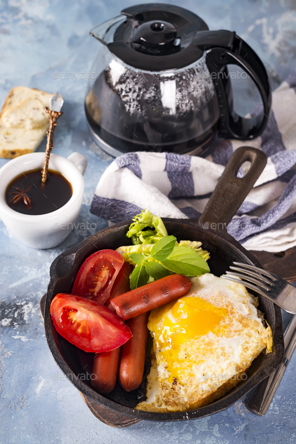 Homemade delicious american breakfast with fried egg, toast, sausage, vegetable, black coffee - Stock Photo - Images
