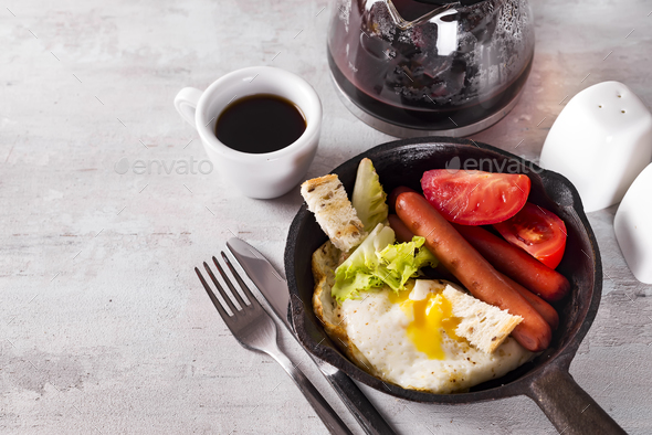 Homemade delicious american breakfast with fried egg, toast, sausage, vegetable, black coffee - Stock Photo - Images