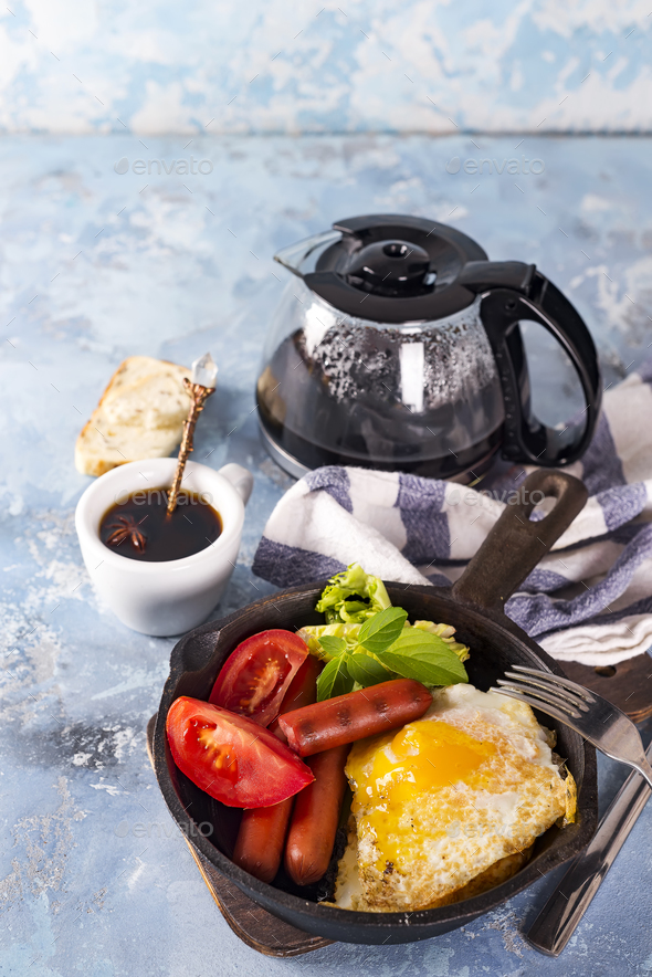 Homemade delicious american breakfast with fried egg, toast, sausage, vegetable, black coffee - Stock Photo - Images
