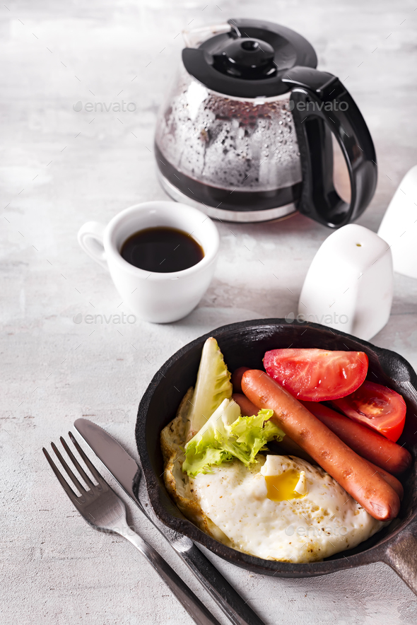 Homemade delicious american breakfast with fried egg, toast, sausage, vegetable, black coffee - Stock Photo - Images