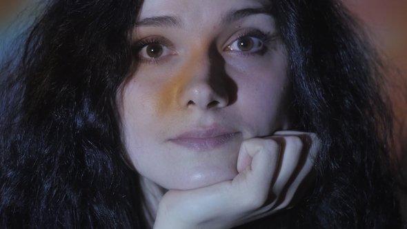 Portrait of a Young Woman Watching a Video or Film on TV or a Computer Monitor alt