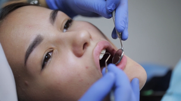 Female Dentist Checking Patient Girl Teeth