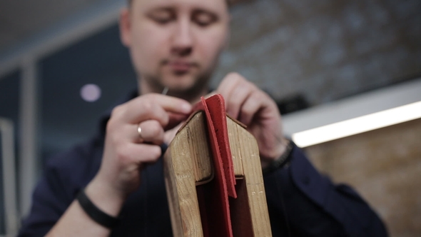 Man Creates a Brown Leather Wallet with His Own Hands with a Needle in the Leather Workshop