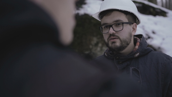Two Speleologists Talking at Enter of the Cave in Forest alt