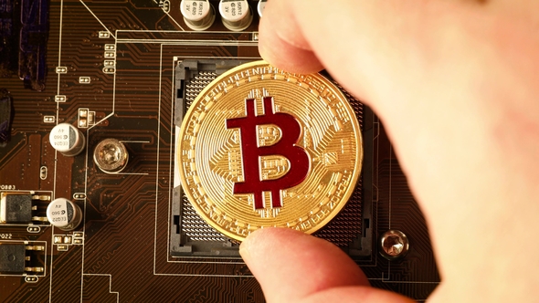 Gold Bit Coin BTC Coins on the Motherboard. Bitcoin Is a Worldwide Cryptocurrency alt
