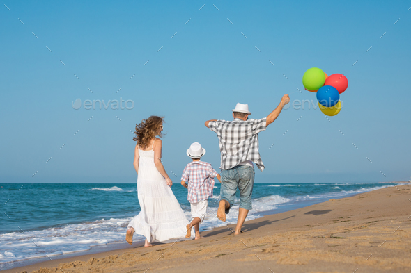 Father mother and son playing on the beach at the day time. - Stock Photo - Images