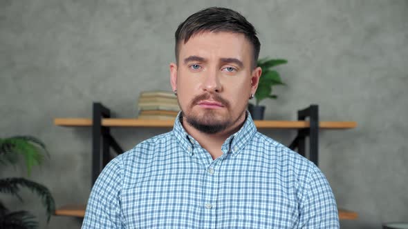 Close up sad bearded businessman  standing in office turns head looking camera alt