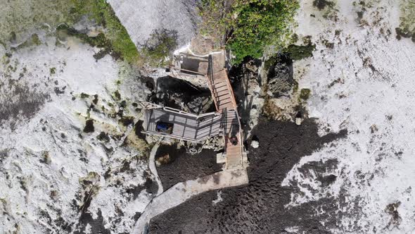The Rock Restaurant in Ocean Built on Cliff at Low Tide on Zanzibar Aerial Top alt