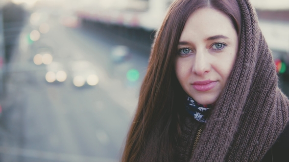 Portrait of a Young Woman on a Background of Urban Traffic.
