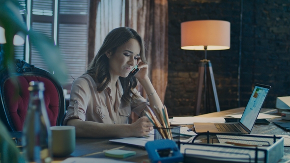 Upset Business Woman Using Phone in Cozy Studio. Depressed Businesswoman alt