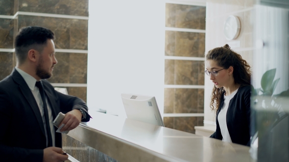 Businessman Guest Talking with Receptionist Girl Standing at Desk in ...