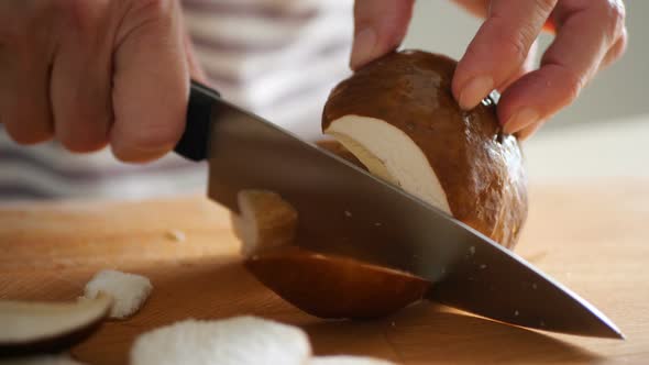 Shot of Woman Chef Cutting Mushrooms on Chopping Wooden Board alt