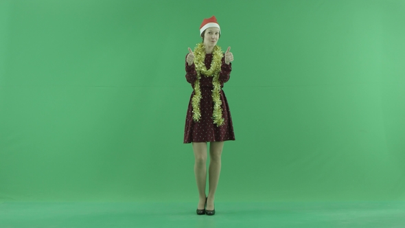 A Young Christmas Woman Shows That Something Is Cool on the Green Screen