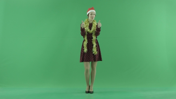 A Young Christmas Woman Shows That Something Is Cool on the Green Screen