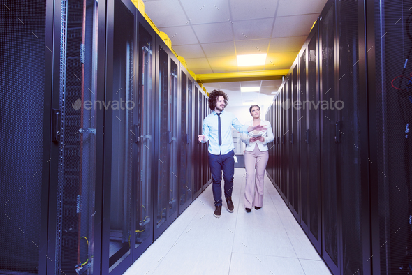 engineer showing working data center server room to female chief Stock Photo by dotshock