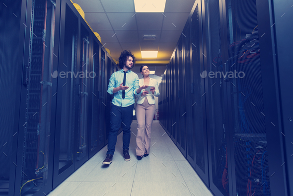 engineer showing working data center server room to female chief Stock Photo by dotshock