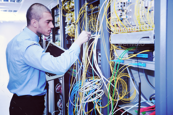 businessman with laptop in network server room Stock Photo by dotshock