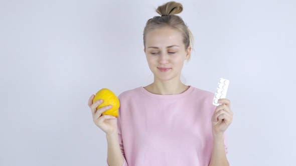 Young Woman Chooses Between Pills and Lemon