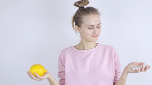 Young Woman Chooses Between Pills and Lemon