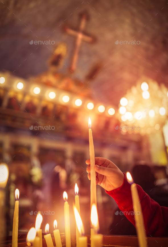 Child puts a candle in the church - Stock Photo - Images