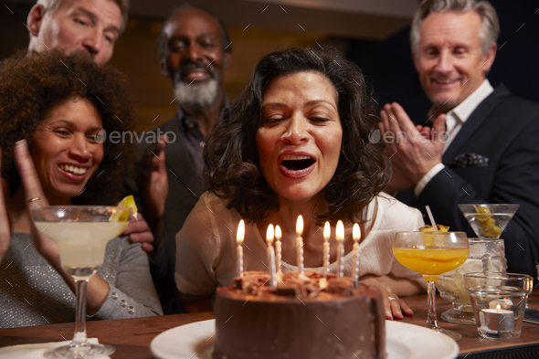 Group Of Middle Aged Friends Celebrating Birthday In Bar Stock Photo by monkeybusiness