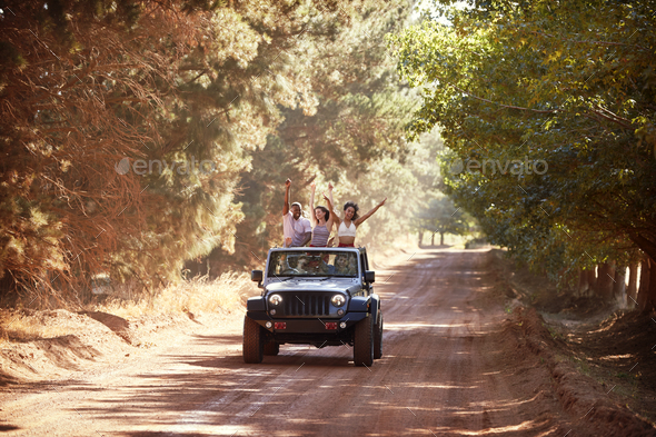 Friends having fun driving in an open top jeep Stock Photo by monkeybusiness