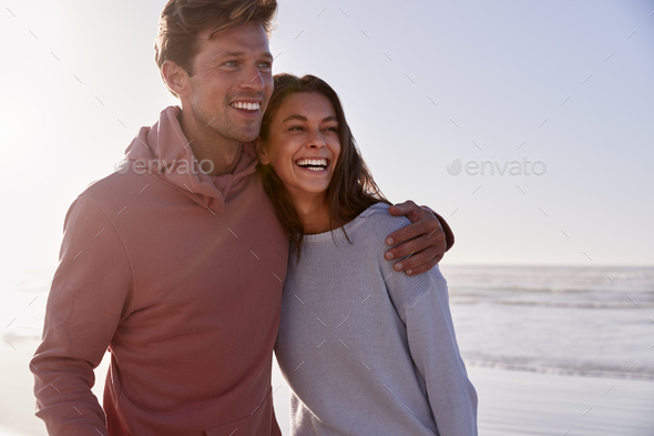 Romantic Couple On Walking Along Winter Beach Together Romantic Couple On Walking Along Winter Beach Together